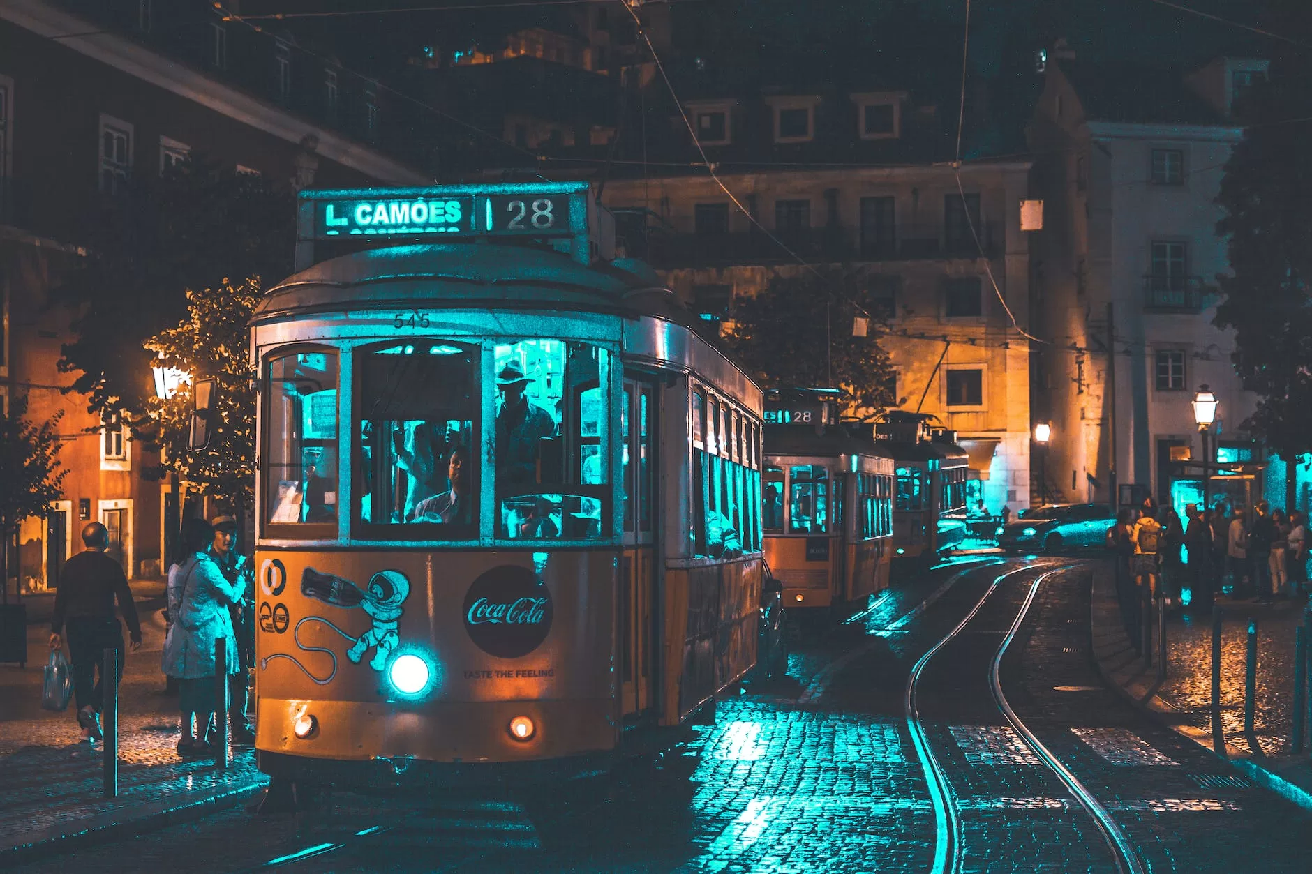 photo of people riding on city tram Lisbon Christmas night