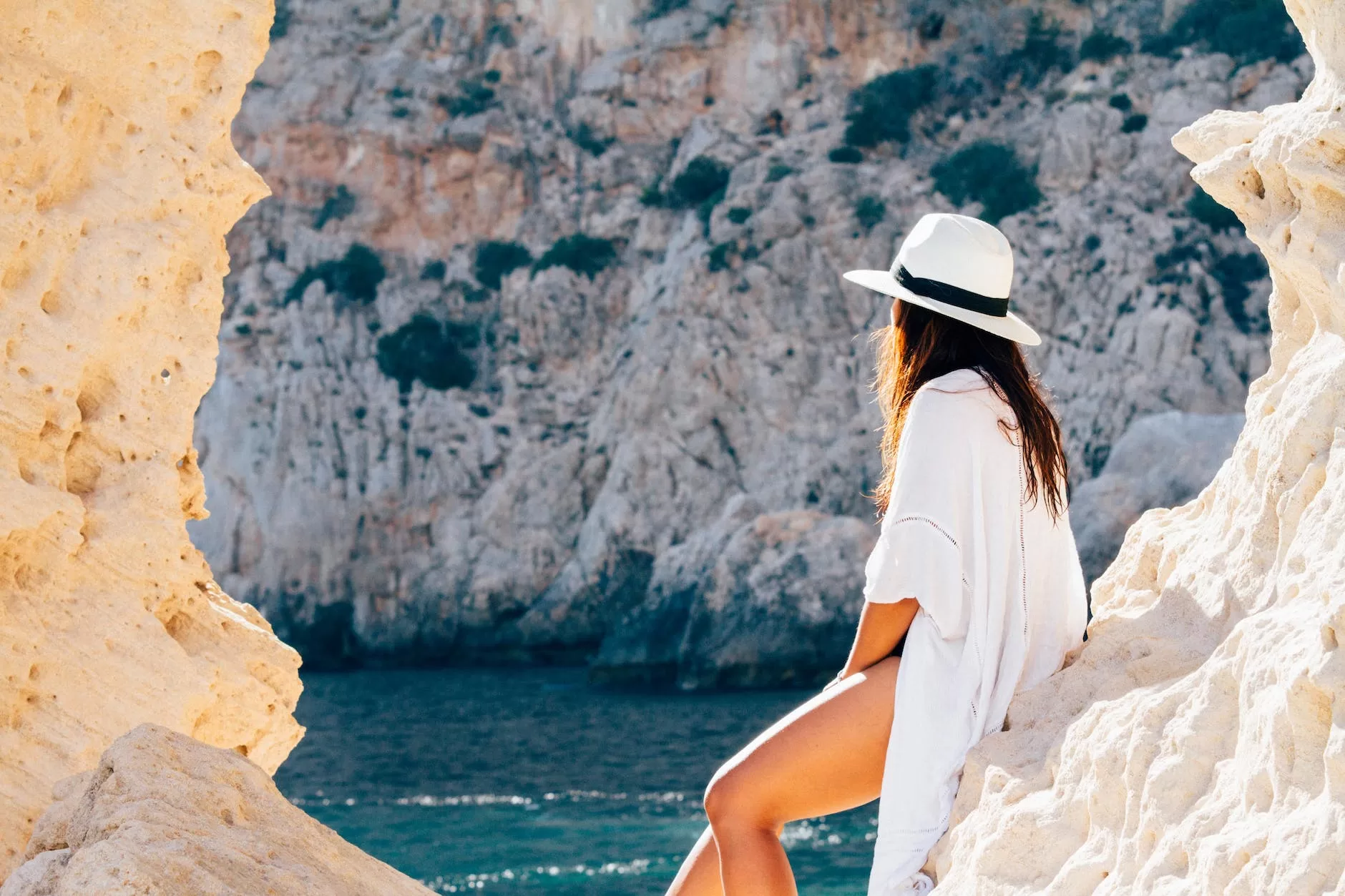 rear view of woman sitting on a rock Best Countries for US Expats to Live 