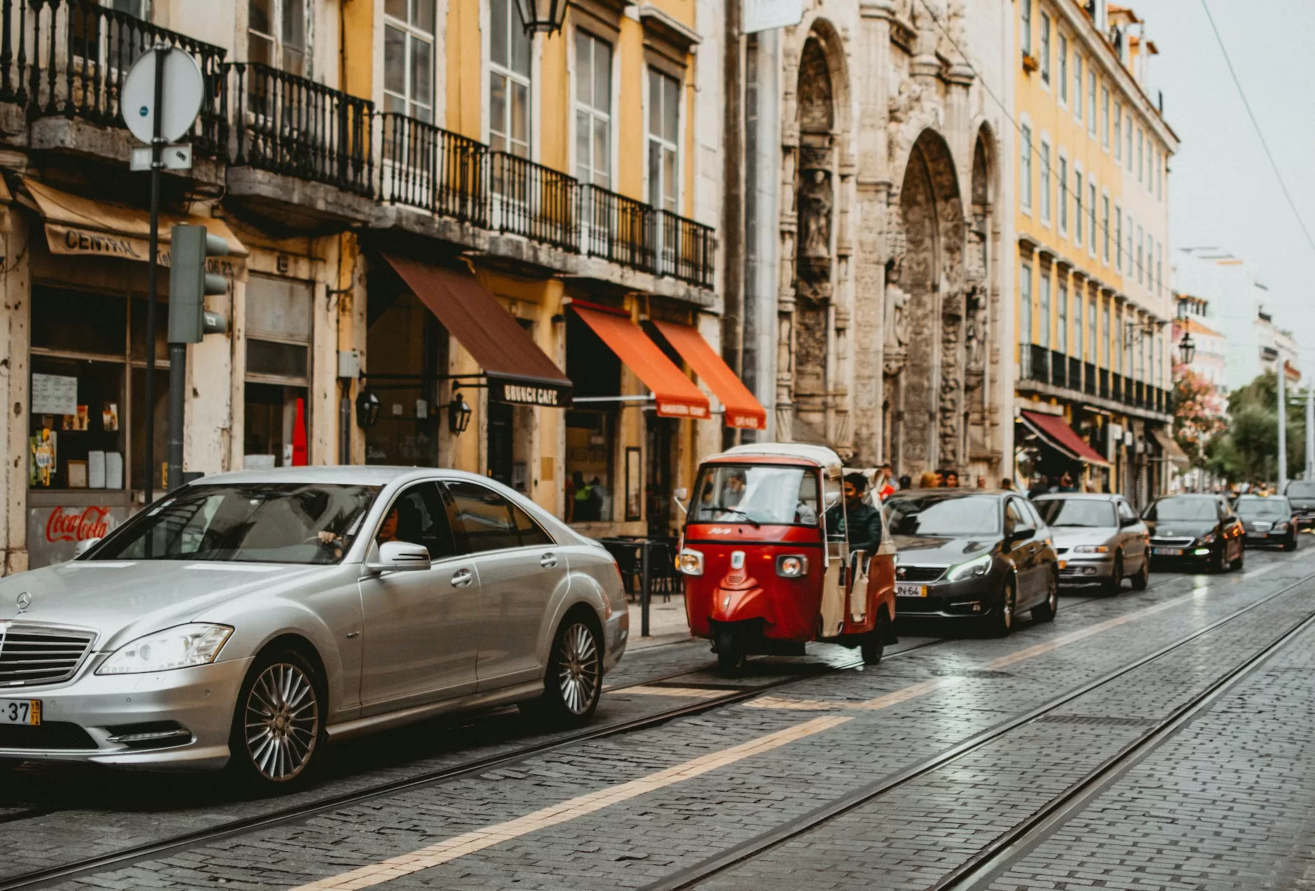 silver sedan beside yellow building