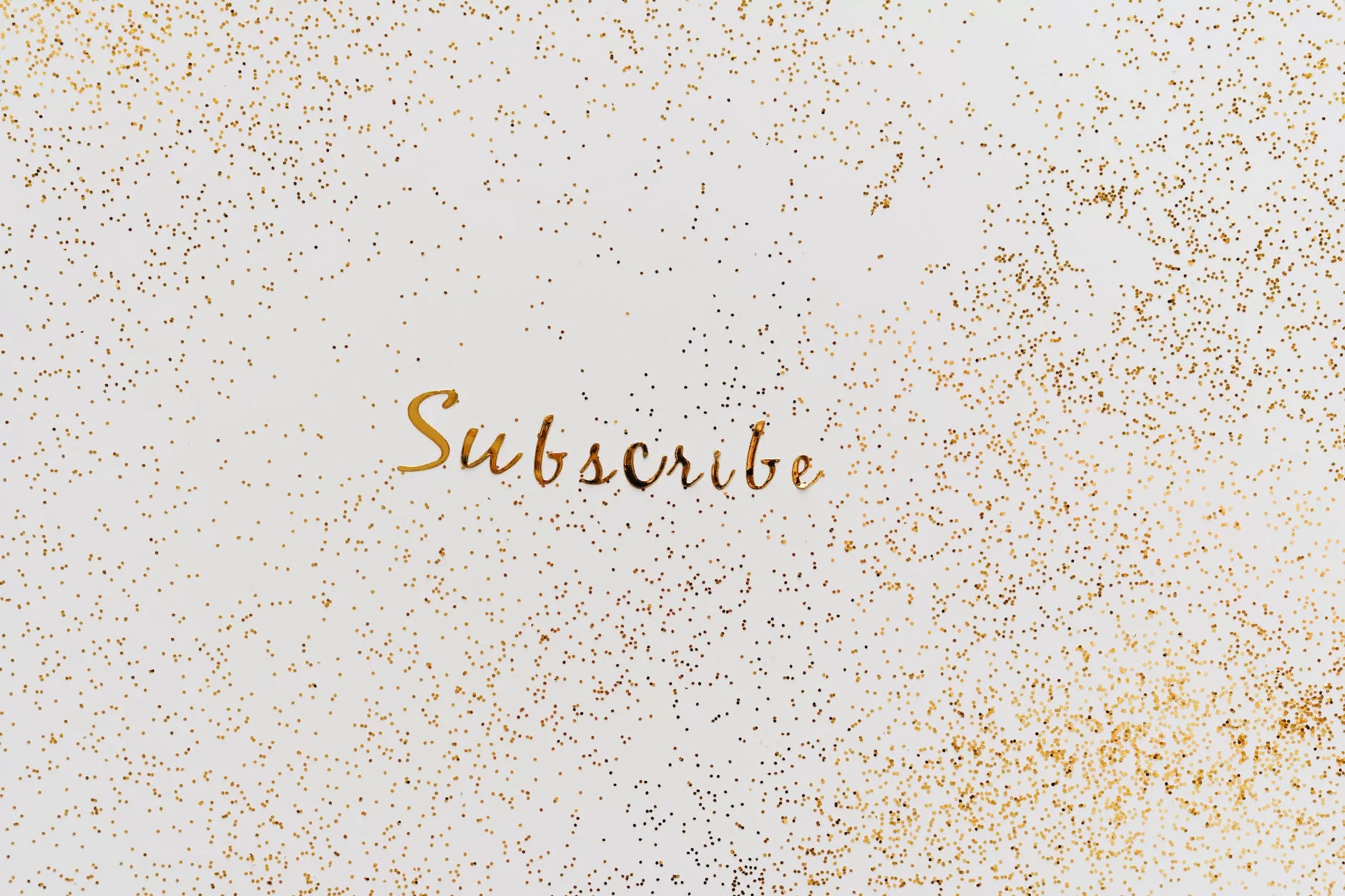 a word subscribe in gold color decorated with scattered glitters