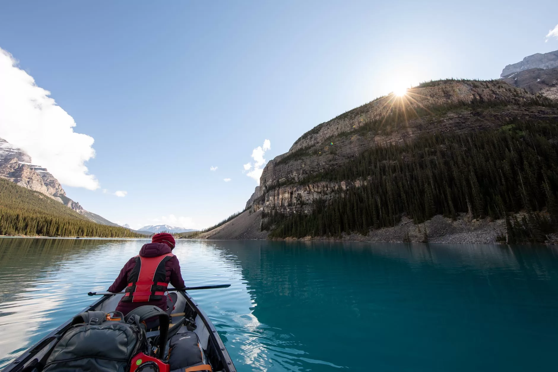 person riding boat in body of water between islands