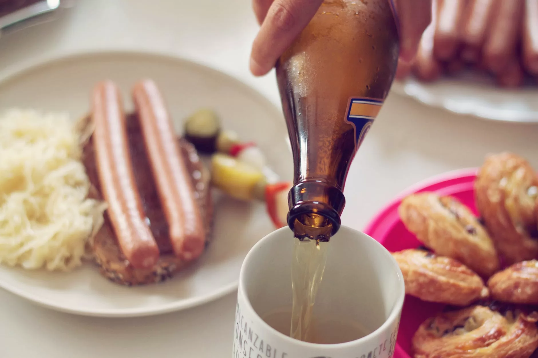 person pouring beer on white mug