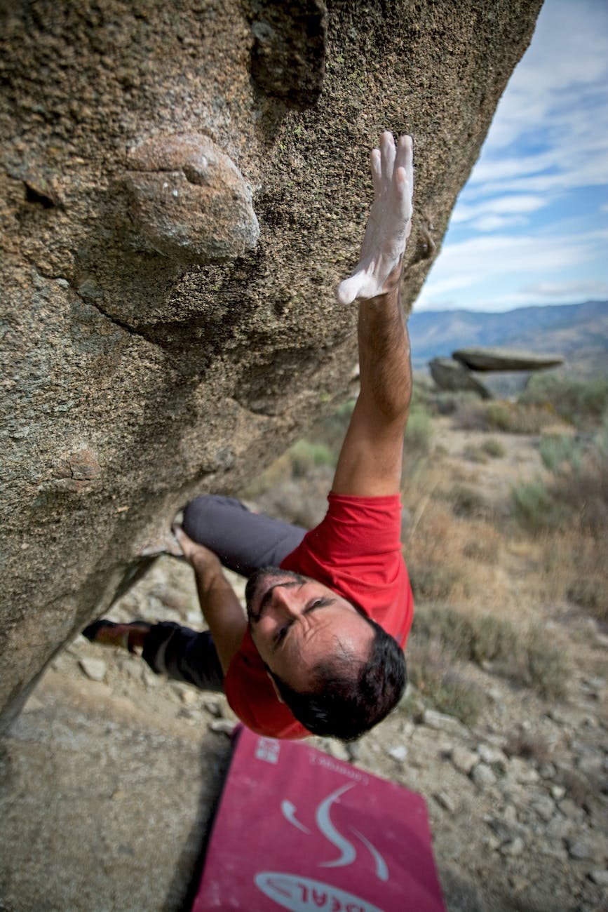 man climbing on gray concrete peak at daytime Canada digital nomad