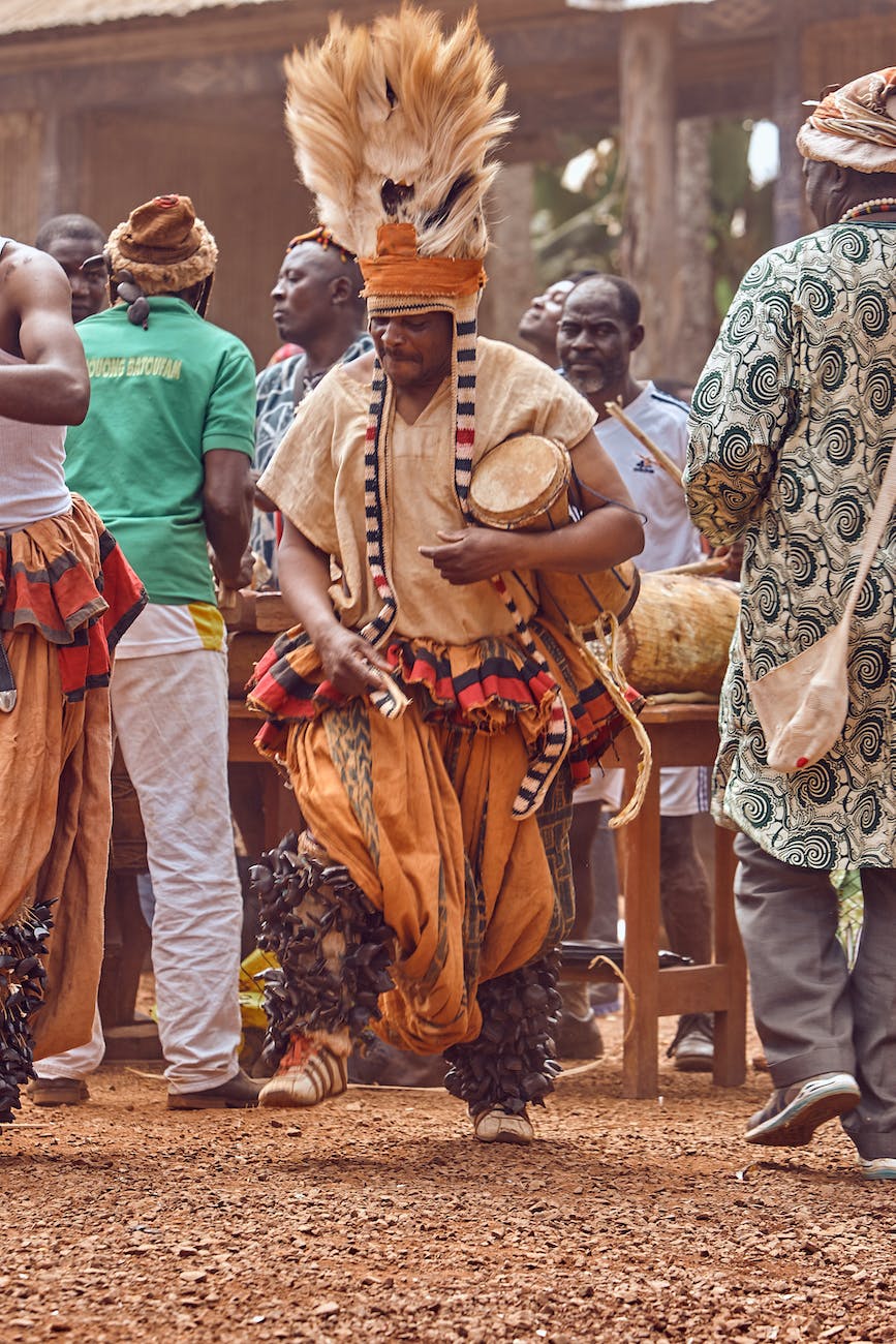 people in traditional dress standing on brown sand