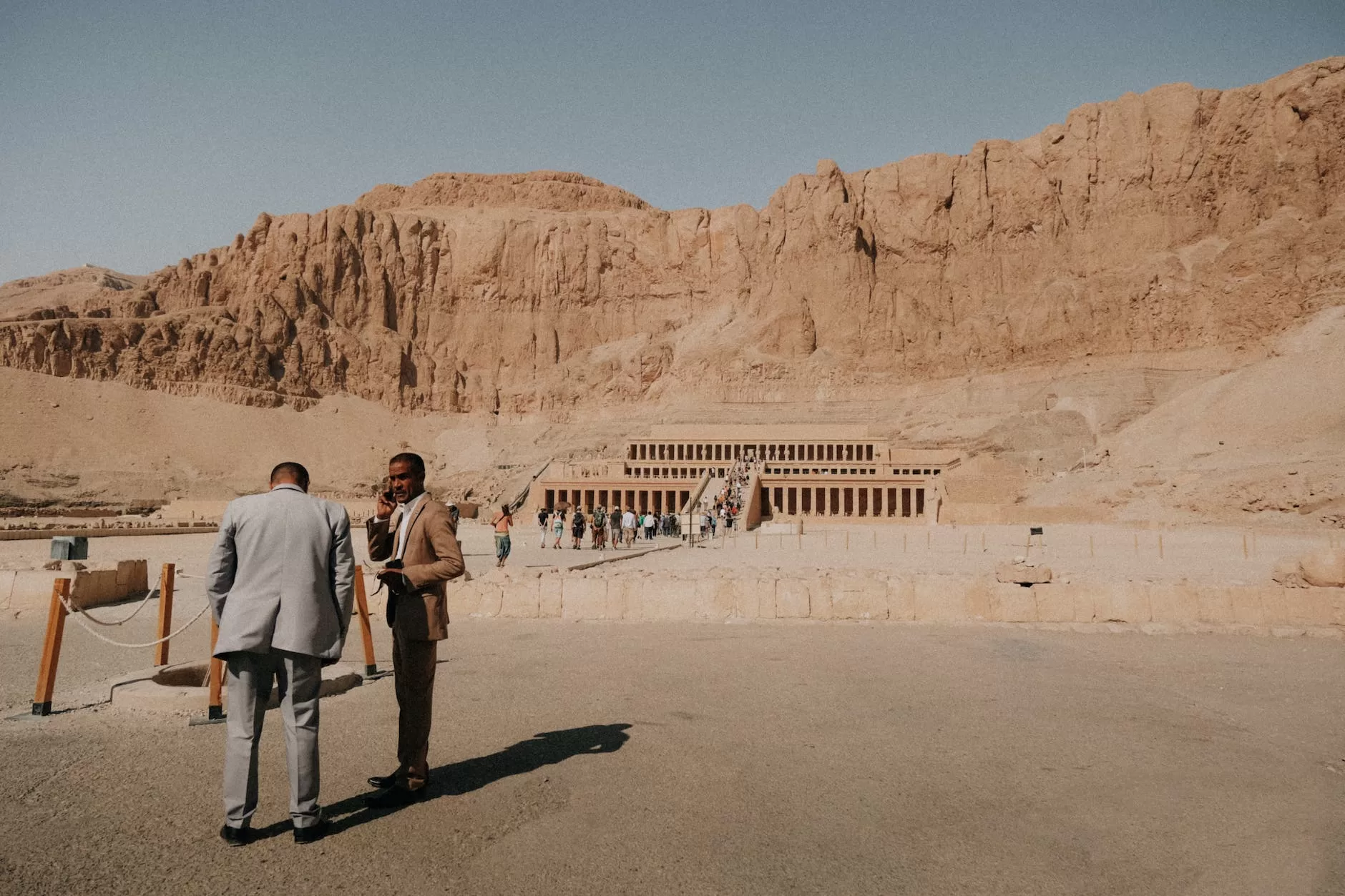 photo of the temple of hatshepsut in egypt with two men in the foreground Exploring africa is great for the diverse landscapes for filmmakers