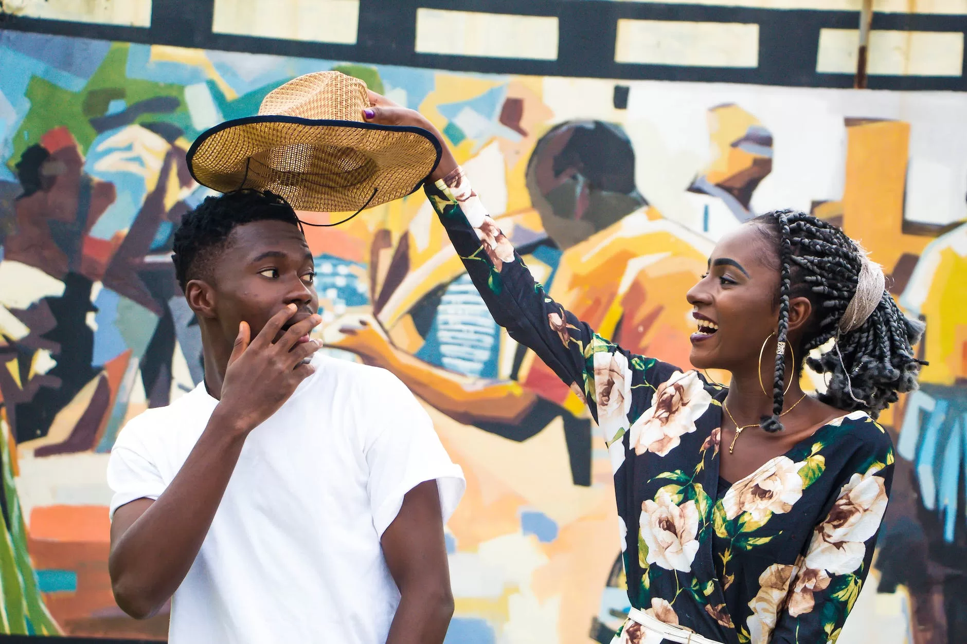 woman holding man s hat as they explore africa