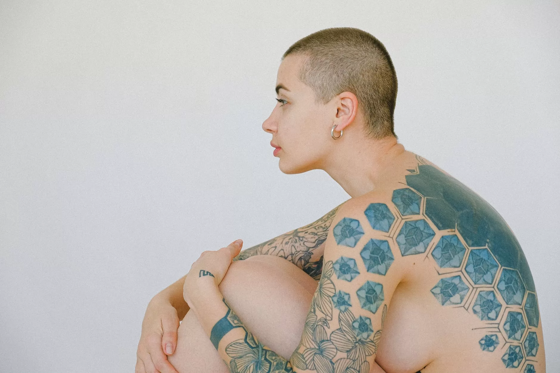 topless woman with tattoo on her right arm