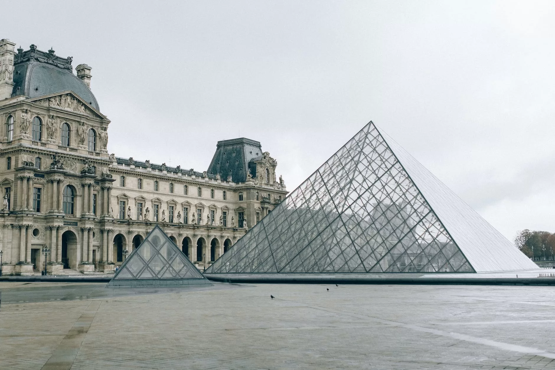 as you Travel to Europe explore the pyramid design in front of a landmark building 