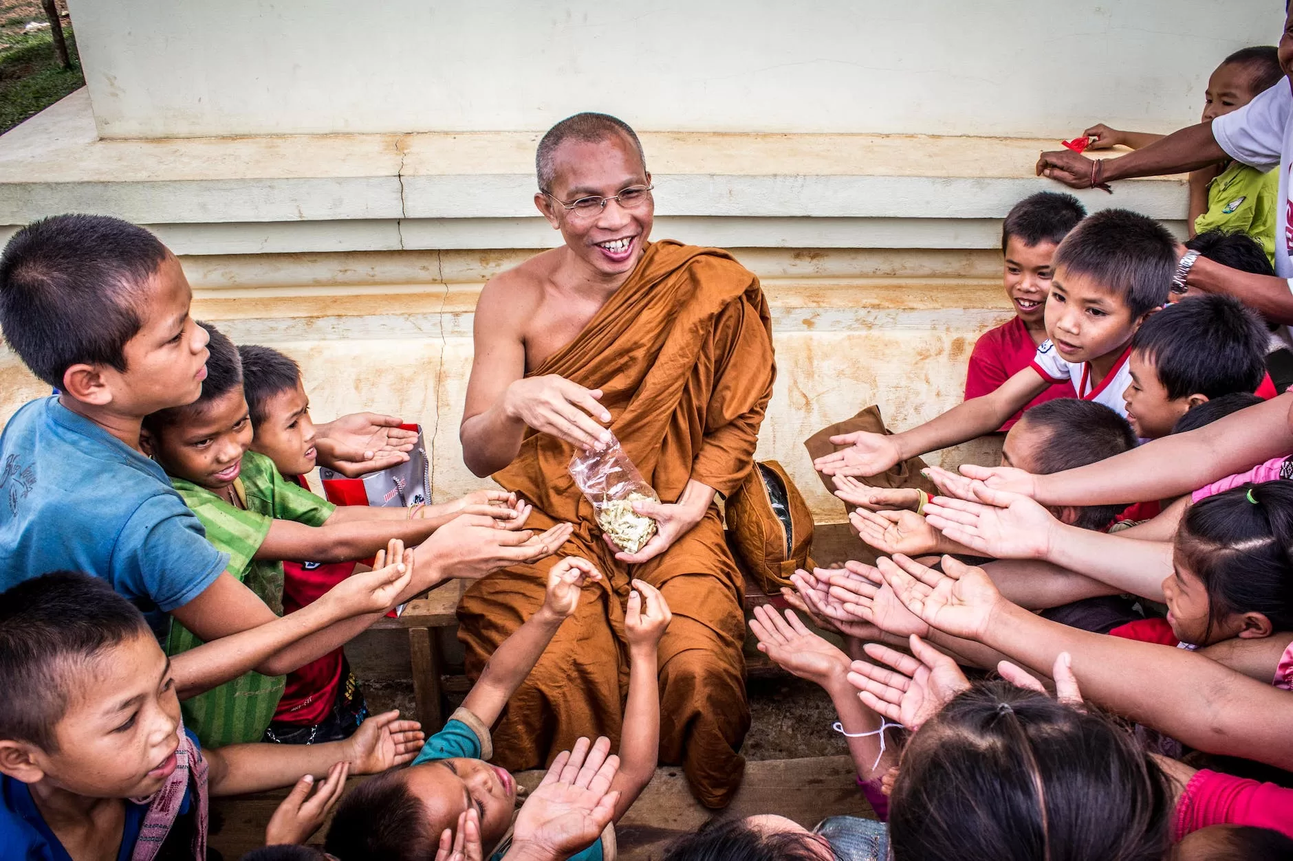 man in monk dress between group of children