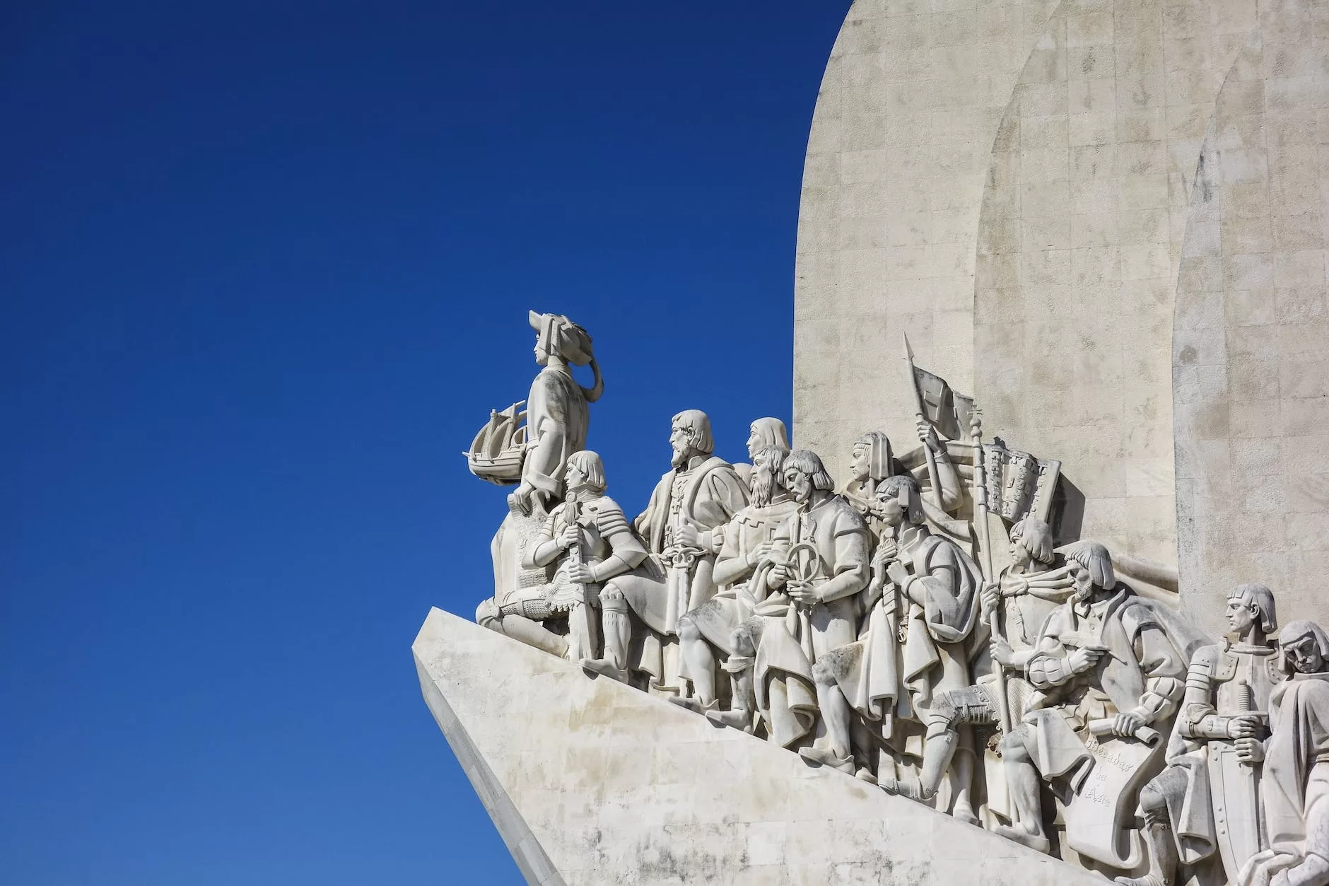 statue on roof under white and blue sky with Vasco da Gama