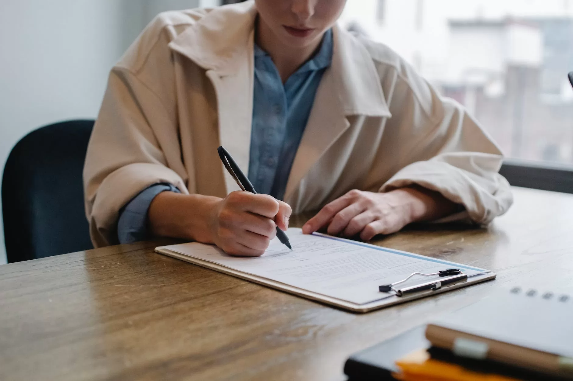focused woman writing in clipboard while hiring candidate scouting trip for digital nomads