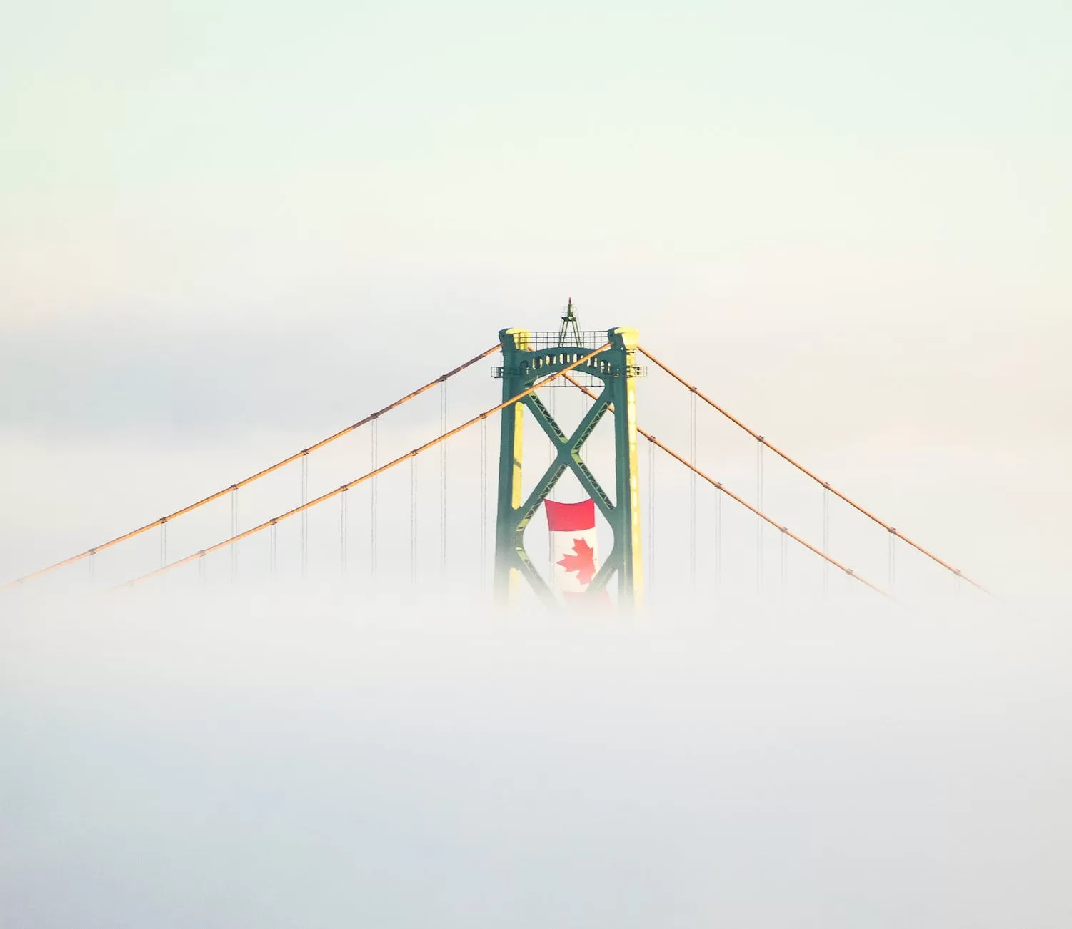 the canadian flag hangs above a  travel blog niche suspension bridge