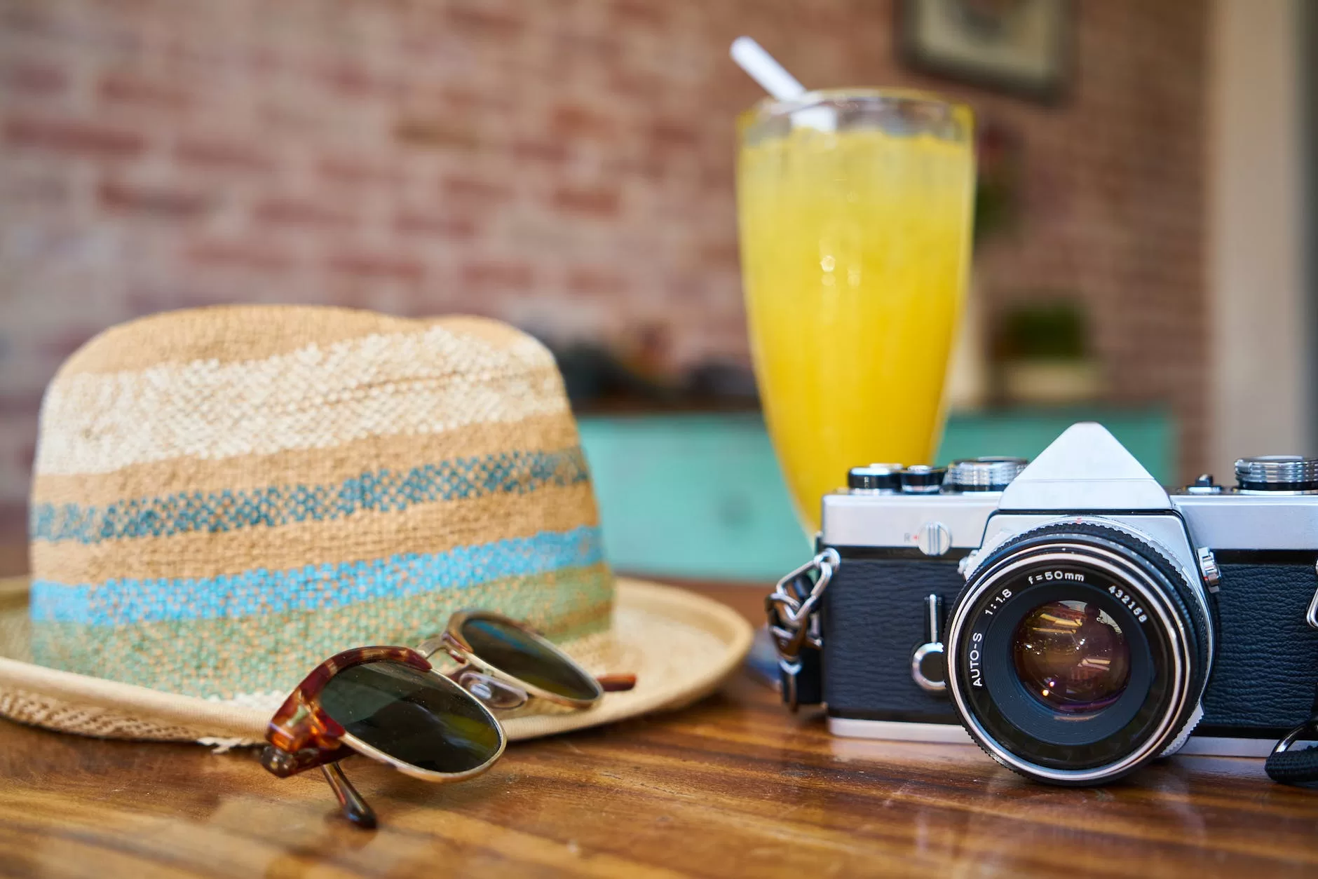 gray and black dslr camera beside sun hat and sunglasses cheap flights